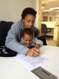 Housing Families First client signs a lease to her new home. 